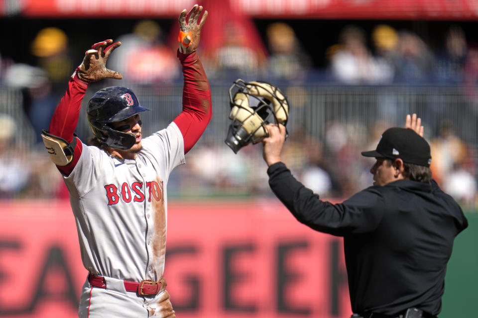 Boston Red Sox's Jarren Duran, left, celebrates after sliding safely into third with a triple as umpire Brian D.J.Reyburn calls timeout during the the first inning of the team's baseball game against the Pittsburgh Pirates in Pittsburgh, Saturday, April 20, 2024. (AP Photo/Gene J. Puskar)