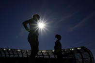 Competitors stand for the national anthem before the prelims of the women's pole vault the U.S. Olympic Track and Field Trials Thursday, June 24, 2021, in Eugene, Ore. (AP Photo/Charlie Riedel)tonal at the