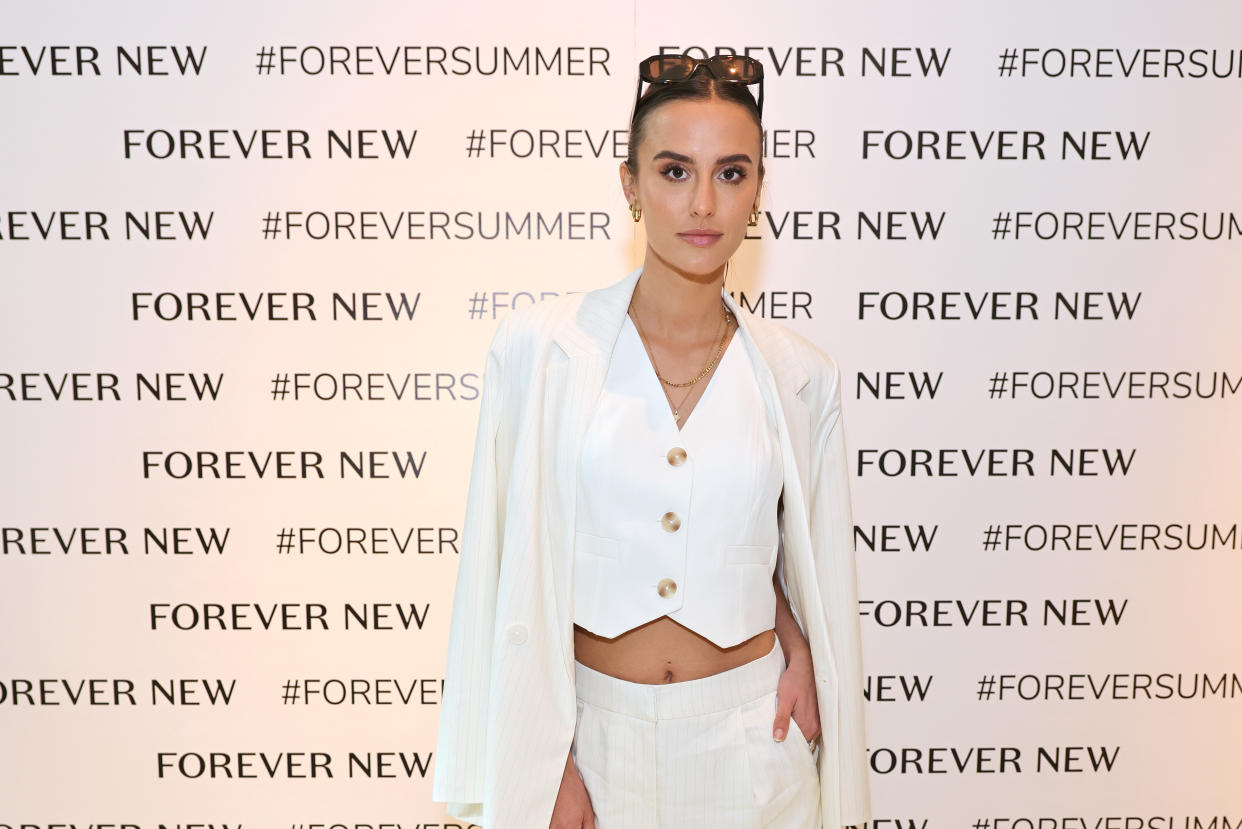 Lucy Watson, wearing a white vest and blazer over her shoulders, attends a VIP lunch celebrating the Forever New London flagship store launch