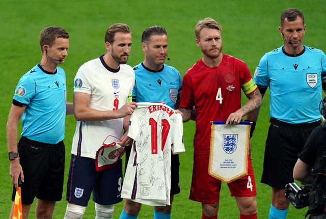 Harry Kane, hands a shirt with Christian Eriksen's name on it to Denmark’s Simon Kjaer before the semi-final 