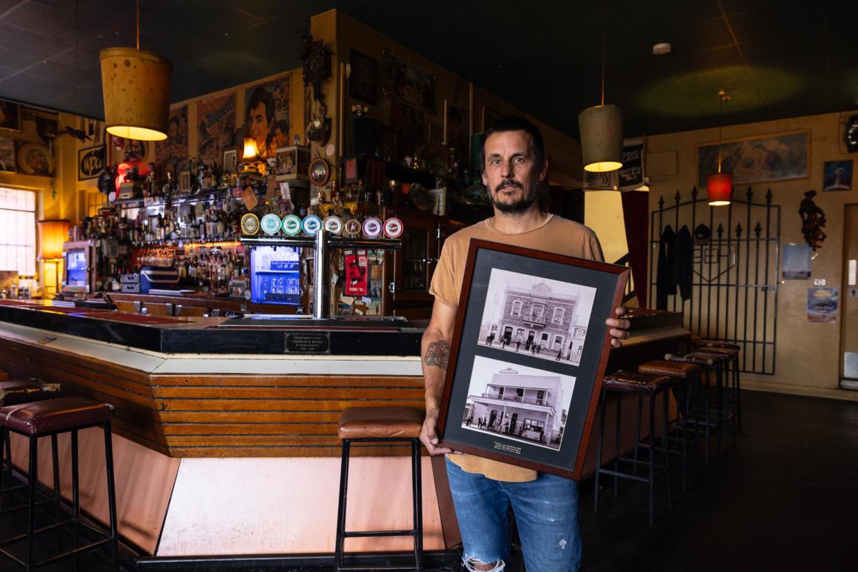 <span>The publican of the Grace Emily hotel, Symon Jarowyj, holds up archival photos of the Adelaide venue, which is one of the city’s oldest pubs and now hosts live music most nights in its band room.</span><span>Photograph: Sia Duff/The Guardian</span>