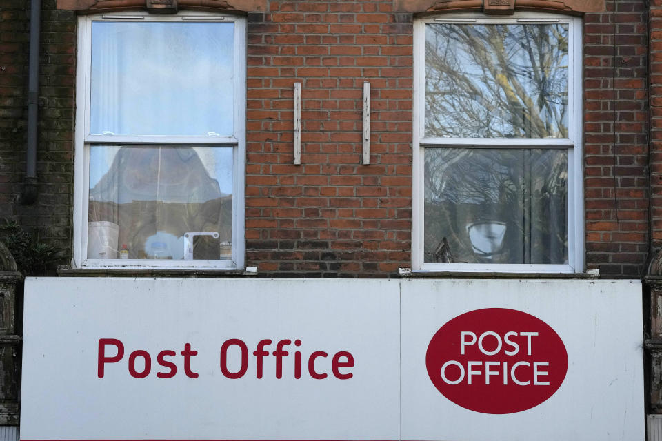 A post office logo on a shop front on a street in London, Tuesday, Jan. 16, 2024. Lawmakers trying to get to the bottom of one of Britain's gravest injustices are questioning bosses of the Post Office and Fujitsu as momentum grew to compensate and clear the names of more than 900 Post Office branch managers wrongly convicted of theft or fraud because of the Japanese company's faulty computer system. (AP Photo/Frank Augstein)