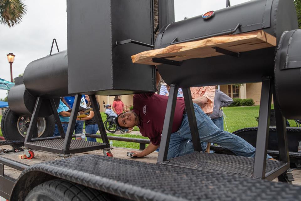 Agricultural mechanics project show judge Leo Jauregui, with AgriLife Extension Service, inspects H.M. KingsvilleÕs barbecue pit with a firebox at Texas A&M-Kingsville on Tuesday, April 23, 2024, in Kingsville, Texas.