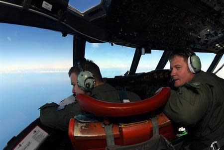 Flight Lieutenant Russell Adams (L) and Flight Engineer Scott Jones look out from the cockpit of a Royal Australian Air Force (RAAF) AP-3C Orion aircraft while searching for the missing Malaysia Airlines Flight MH370 over the southern Indian Ocean March 26, 2014. REUTERS/Paul Kane/Pool