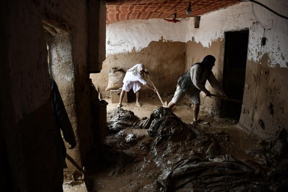 Afghan men shovel mud from a house following flash floods after heavy rainfall at a village in Baghlan-e-Markazi district of Baghlan province on 11 May 2024 (AFP via Getty Images)
