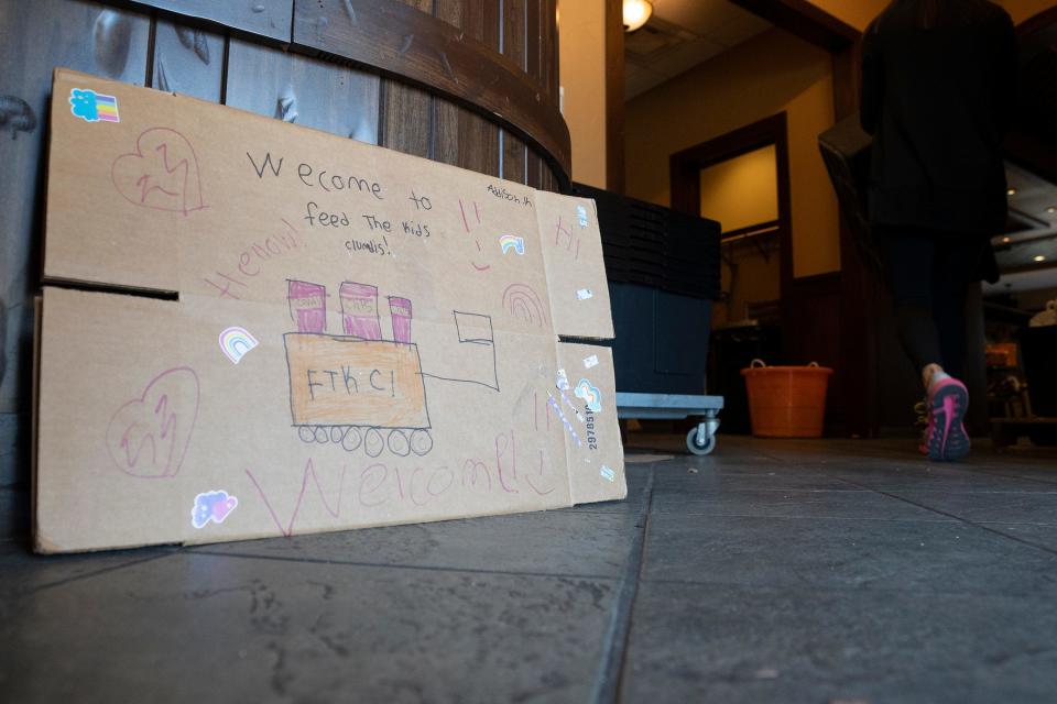 Ashley Kanney, founder of Feed the Kids Columbus, walks by a sign made by her kids to welcome volunteers during a blessing bag packing event at the former Montgomery Inn in Dublin. Kanney started the group in her garage in 2019 and it now serves 6,000 kids in 25 schools in Columbus City Schools, Dublin Schools, Groveport-Madison School and South-Western City Schools.