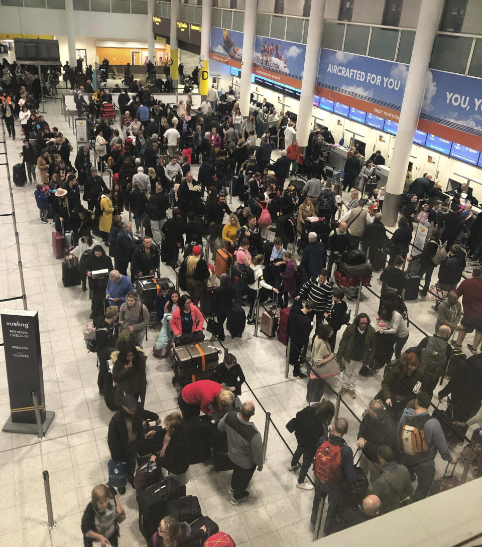 Queues of passengers wait at the check-in desks at Gatwick Airport, as the airport remains closed and with incoming flights delayed or diverted to other airports, after drones were spotted over the airfield last night and this morning Thursday Dec. 20, 2018. London's Gatwick Airport remained shut during the busy holiday period Thursday while police and airport officials investigate reports that drones were flying in the area of the airfield. (Thomas Hornall/PA via AP)