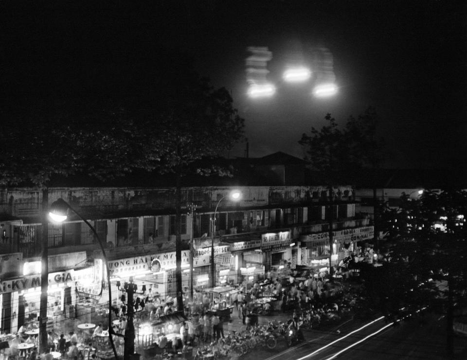 With Saigon nightlife in full swing in the Cholon section, flares burst just two miles away as U.S. planes and helicopters attack Viet Cong guerrillas who were infiltrating two southern precincts of the capital, Sept. 9, 1966. (AP Photo)
