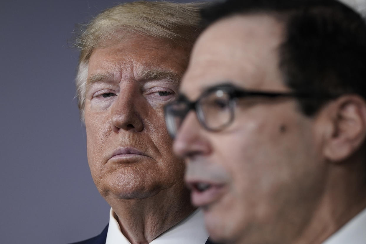 WASHINGTON, DC - MARCH 17:  (L-R) U.S. President Donald Trump looks on as Treasury Secretary Steven Mnuchin speaks during a briefing about the coronavirus outbreak in the press briefing room at the White House on March 17, 2020 in Washington, DC. The Trump administration is considering an $850 billion stimulus package to counter the economic fallout as the coronavirus spreads. (Photo by Drew Angerer/Getty Images)