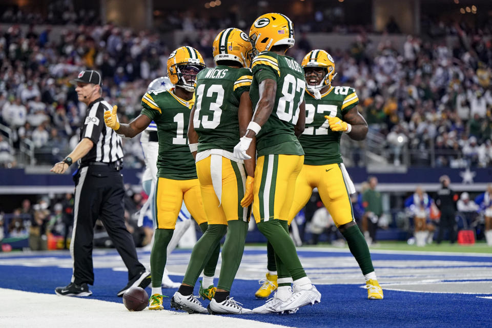 Green Bay Packers wide receiver Dontayvion Wicks (13) celebrates his second quarter touchdown catch with wide receiver Jayden Reed (11), wide receiver Romeo Doubs (87) and running back Patrick Taylor (27) during the first half of an NFL football game against the Dallas Cowboys, Sunday, Jan. 14, 2024, in Arlington, Texas. (AP Photo/Sam Hodde)