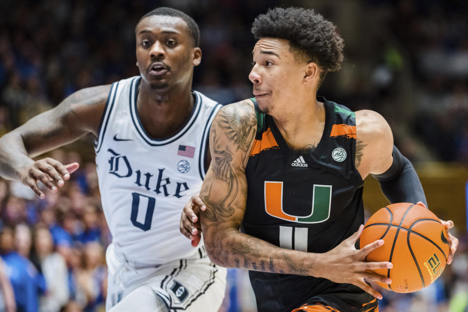 Miami guard Jordan Miller (11) drives to the basket while guarded by Duke forward Dariq Whitehead (0) in the first half of an NCAA college basketball game on Saturday, Jan. 21, 2023, in Durham, N.C. (AP Photo/Jacob Kupferman)