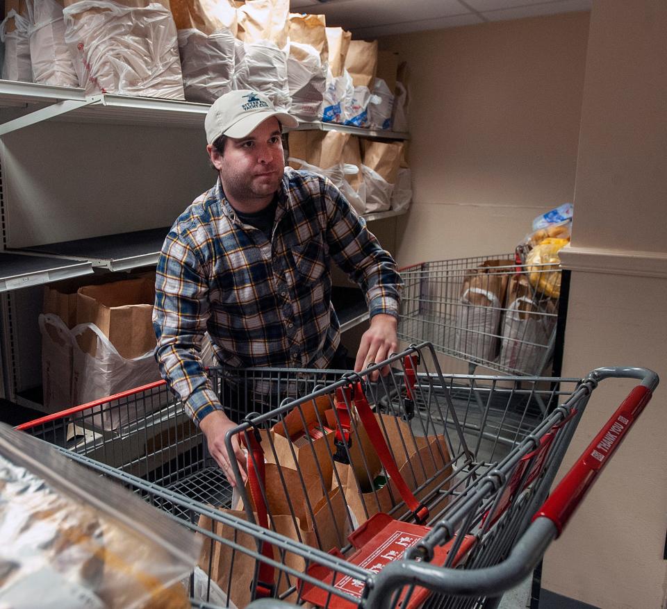 Volunteer Matt Neal prepares groceries at the Pearl Street Cupboard & Cafe at Park in Framingham, March 22, 2024.