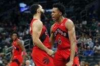 Toronto Raptors' Scottie Barnes (4) reacts with teammate Fred VanVleet after scoring during the second half of an NBA basketball game against the Boston Celtics, Friday, Oct. 22, 2021, in Boston. (AP Photo/Michael Dwyer)