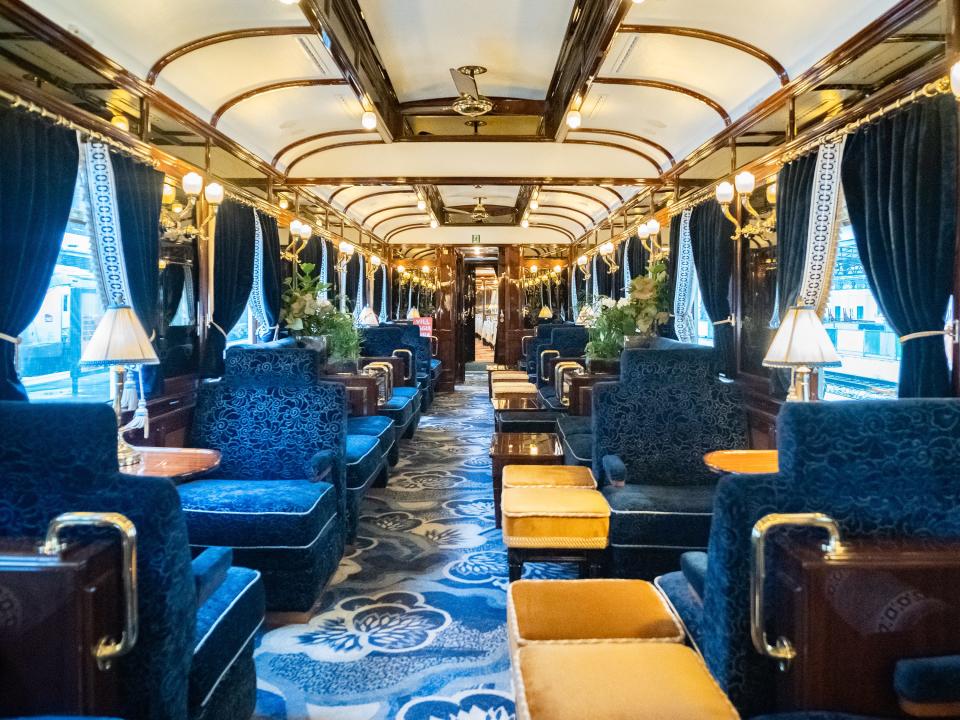 Inside a luxury train's bar car with navy blue seating and curtains