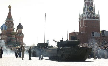 A T-14 Armata tank (R) is attached to a towing vehicle with ropes after it stopped during a rehearsal for the Victory Day parade in Red Square in central Moscow, Russia, May 7, 2015. REUTERS/Grigory Dukor