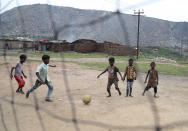 In this Oct. 23, 2019, photo, children of laborers who work in coal fields play a game of soccer in the village of Rajapur in Jharia, a remote corner of eastern Jharkhand state, India. The fires started in coal pits in eastern India in 1916. More than a century later, they are still spewing flames and clouds of poisonous fumes into the air, forcing residents to brave sizzling temperatures, deadly sinkholes and toxic gases. (AP Photo/Aijaz Rahi)