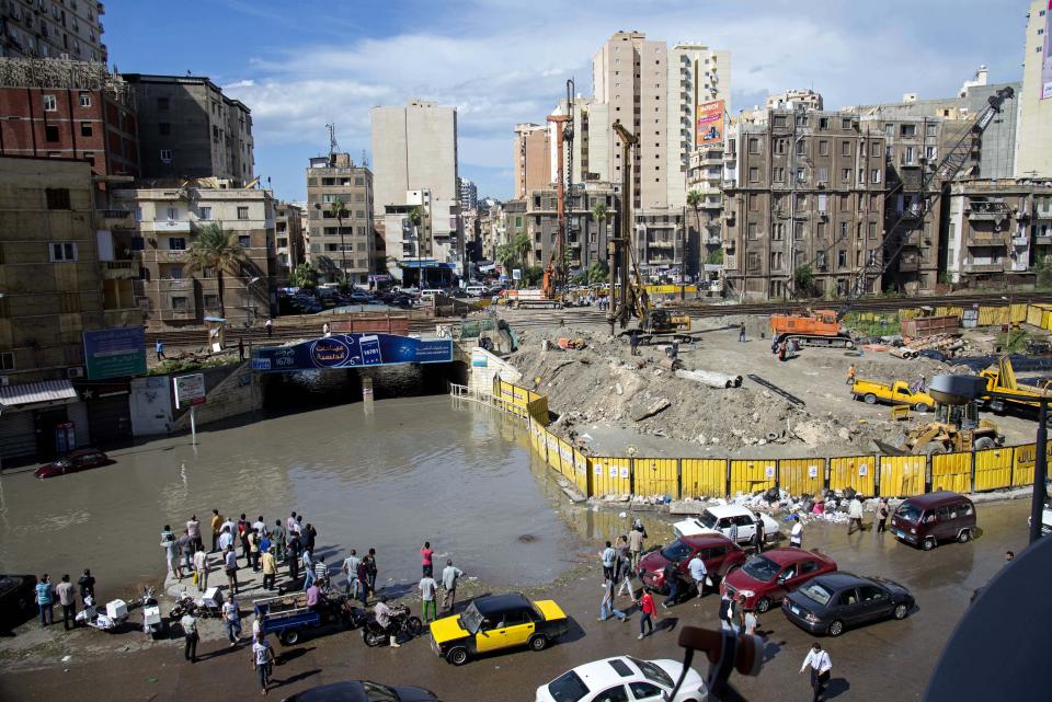 FILE - In this Oct. 25, 2015 file photo, Egyptians check floodwaters after a heavy rainfall in the coastal city of Alexandria, Egypt. Alexandria, which has survived invasions, fires and earthquakes since it was founded by Alexander the Great more than 2,000 years ago, now faces a new menace from climate change. Rising sea levels threaten to inundate poorer neighborhoods and archaeological sites, prompting authorities to erect concrete barriers out at sea to hold back the surging waves. (AP Photo/Heba Khamis, File)