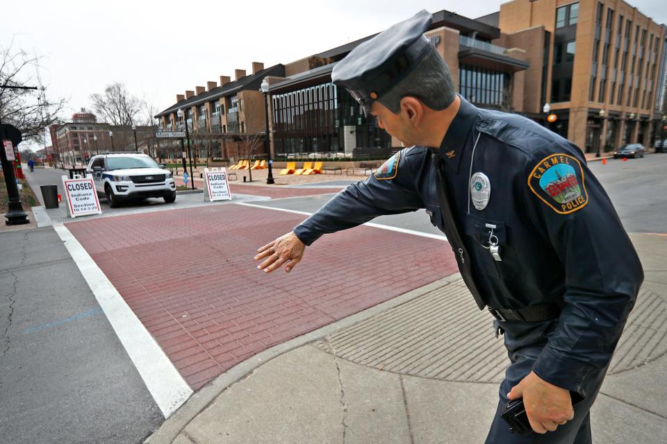 A policeman statue, by J. Seward Johnson, appears to stop traffic on Main Street in Carme, Thursday, March 26, 2020.