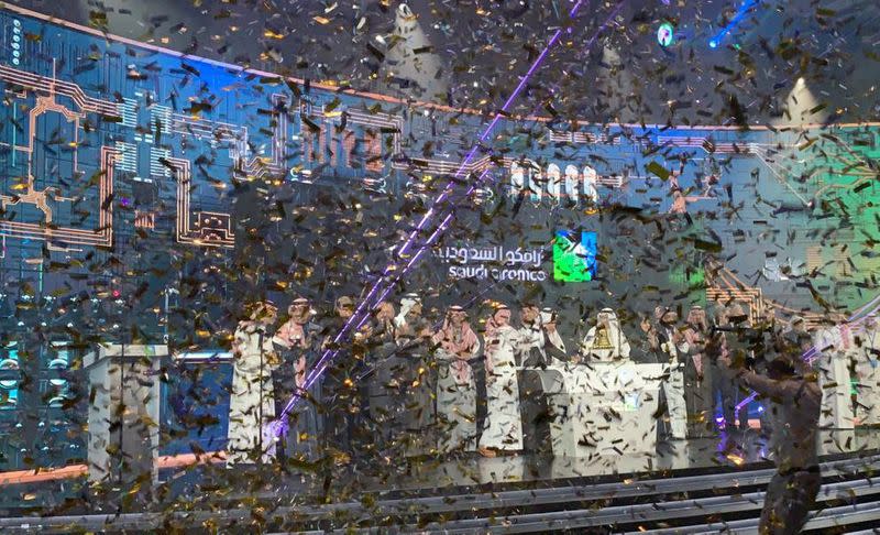 FILE PHOTO: Participants celebrate during the official ceremony marking the debut of Saudi Aramco's IPO on the Riyadh's stock market, in Riyadh