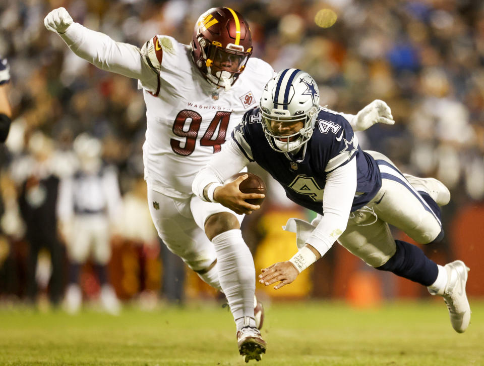 Dallas Cowboys quarterback Dak Prescott (4) carries the ball as Washington Commanders defensive tackle Daron Payne (94) defends during the first half of a NFL football game between the Dallas Cowboys and the Washington Commanders on Sunday, Jan. 8, 2023 at FedExField in Landover, Md. (Shaban Athuman/Richmond Times-Dispatch via AP)