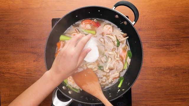 Pouring slurry into gravy in a pan