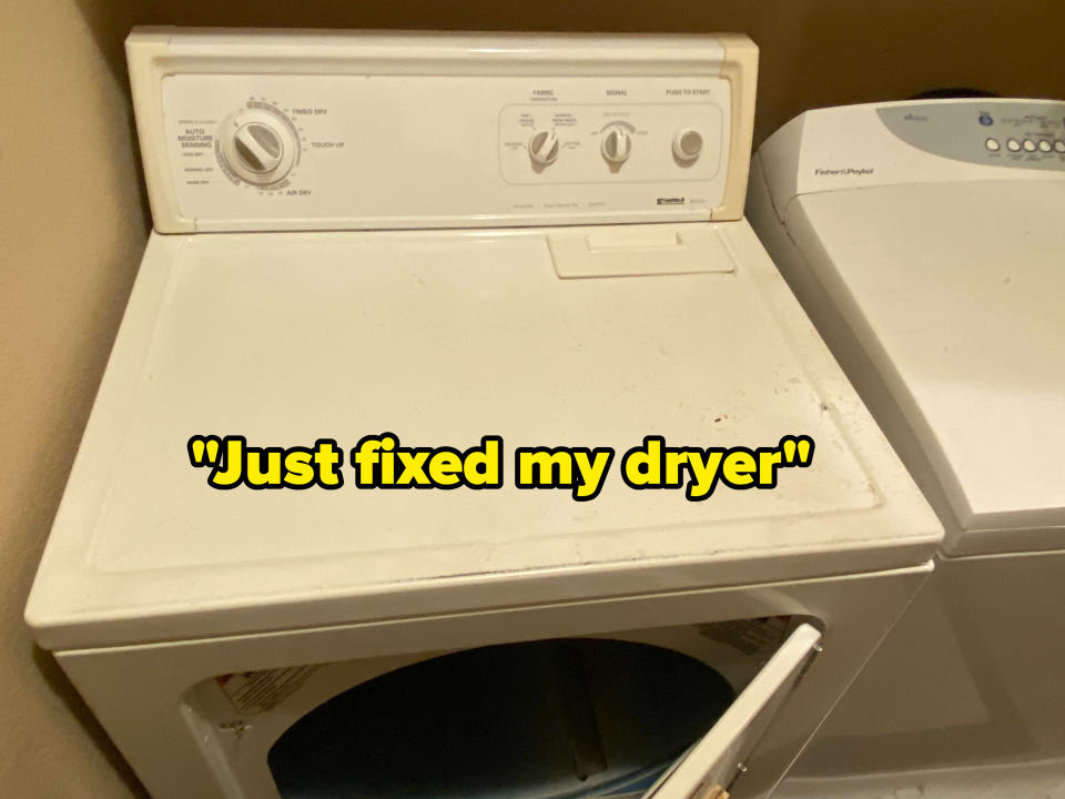 A washing machine with an open lid; its control panel has knobs and buttons for operation