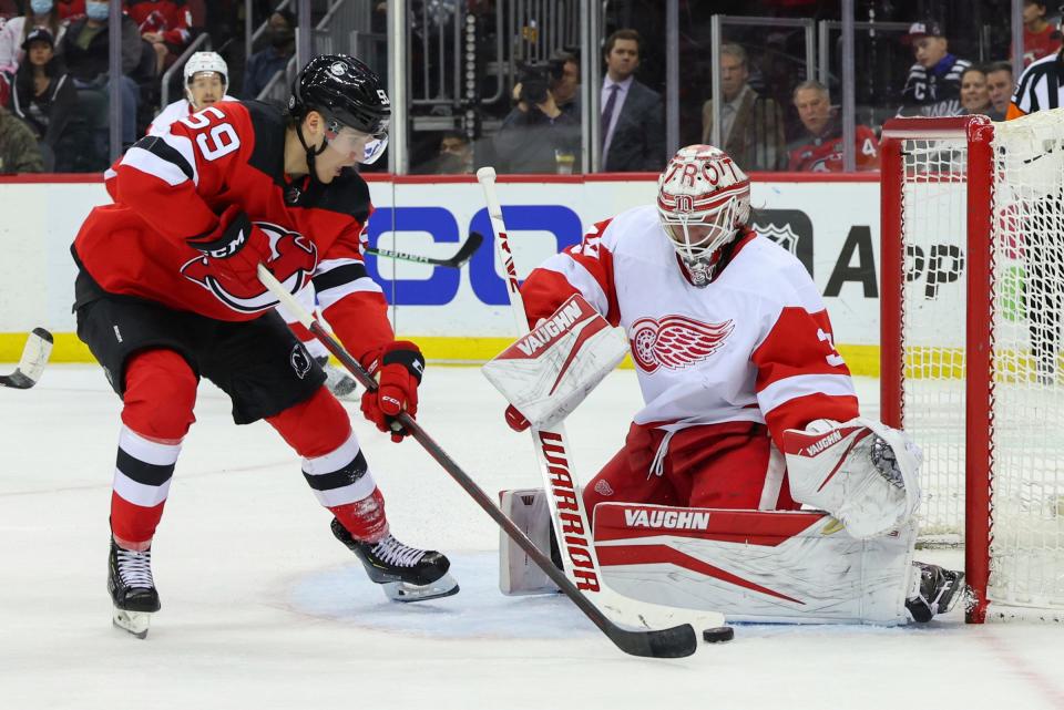 New Jersey Devils center Janne Kuokkanen (59) skates with the puck while Detroit Red Wings goaltender Alex Nedeljkovic (39) defends his net during the second period at Prudential Center in Newark, N.J., on Sunday, April 24, 2022.