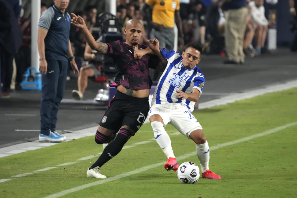 Mexico defenseman Luis Rodriguez, left, and Honduras defenseman Diego Rodriguez compete for the ball during the first half of a CONCACAF Gold Cup soccer match, Saturday, July 24, 2021, in Glendale, Ariz. (AP Photo/Rick Scuteri)