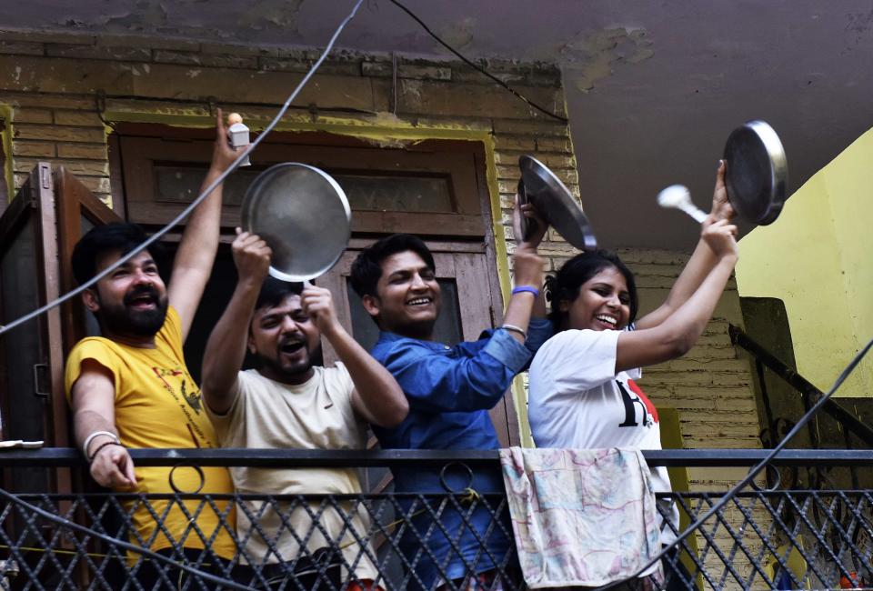 NEW DELHI, INDIA - MARCH 22: People throng to their balconies and streets in a show of appreciation for those engaged in providing essential services to tackle the coronavirus, at Arjun Nagar, on March 22, 2020 in New Delhi, India. A country stalked by an eerie silence came alive, suddenly, at 5pm. Sounds of clapping and beating utensils rang out of residential areas, houses and high-rises, lifting the sombre Sunday mood. Responding to Prime Minister Narendra Modis appeals, citizens across the country came out of their homes and in their balconies, clapping, beating utensils and even ringing bells as a mark of solidarity with health officials and emergency workers who are working tirelessly in the wake of the Covid-19 outbreak. (Photo by Mohd Zakir/Hindustan Times via Getty Images)