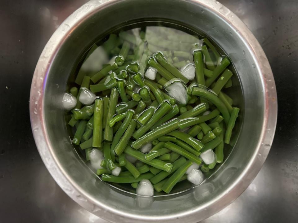 green beans blanching in a bowl of ice water