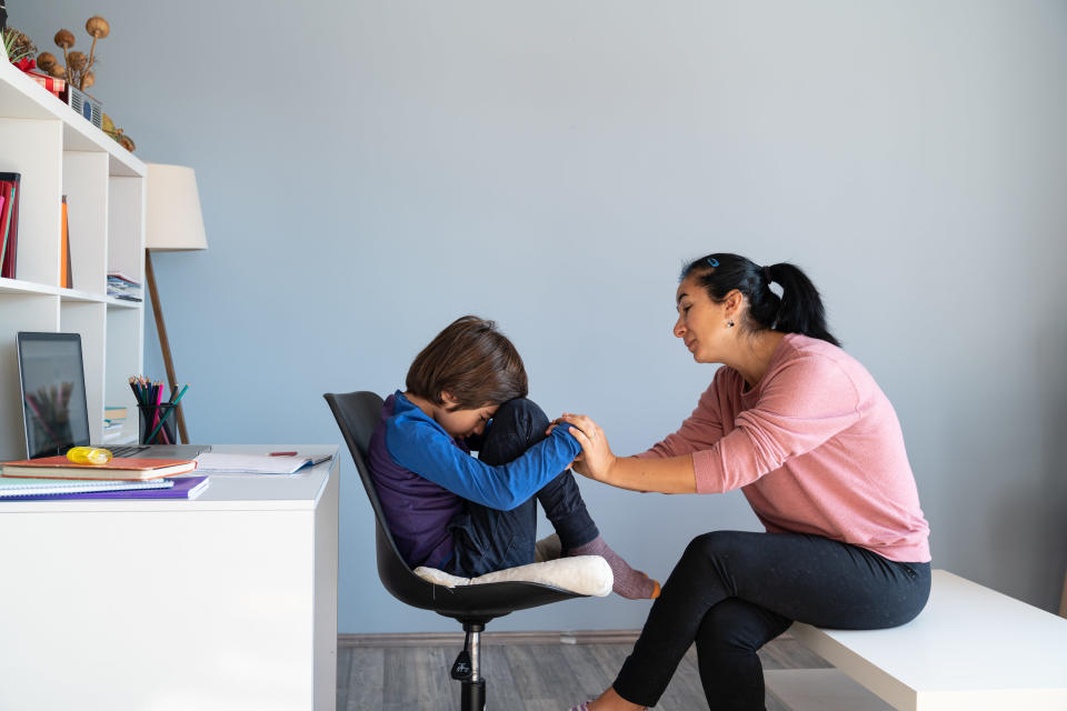 A therapist trying to talk to a young person on a chair