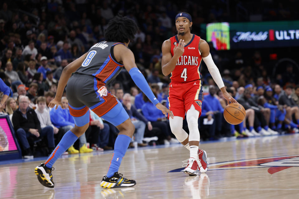 New Orleans Pelicans guard Devonte' Graham (4) goes against Oklahoma City Thunder forward Jalen Williams (8) during the second half of an NBA basketball game Friday, Dec. 23, 2022, in Oklahoma City. (AP Photo/Garett Fisbeck)