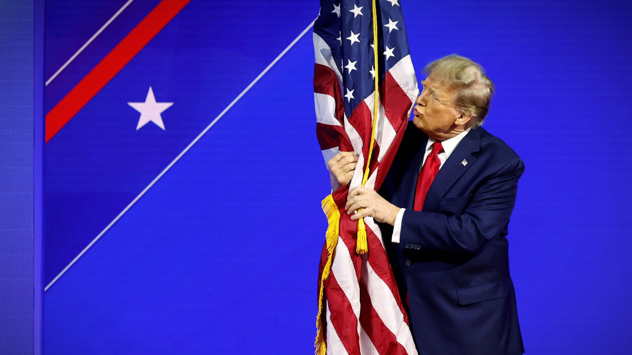  Donald Trump kisses a flag. 