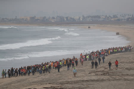 People take part in a gathering in support of the migrant caravan in San Diego, U.S., close to the border wall between the United States and Mexico, as seen from Tijuana, Mexico December 10, 2018. REUTERS/Carlos Garcia Rawlins