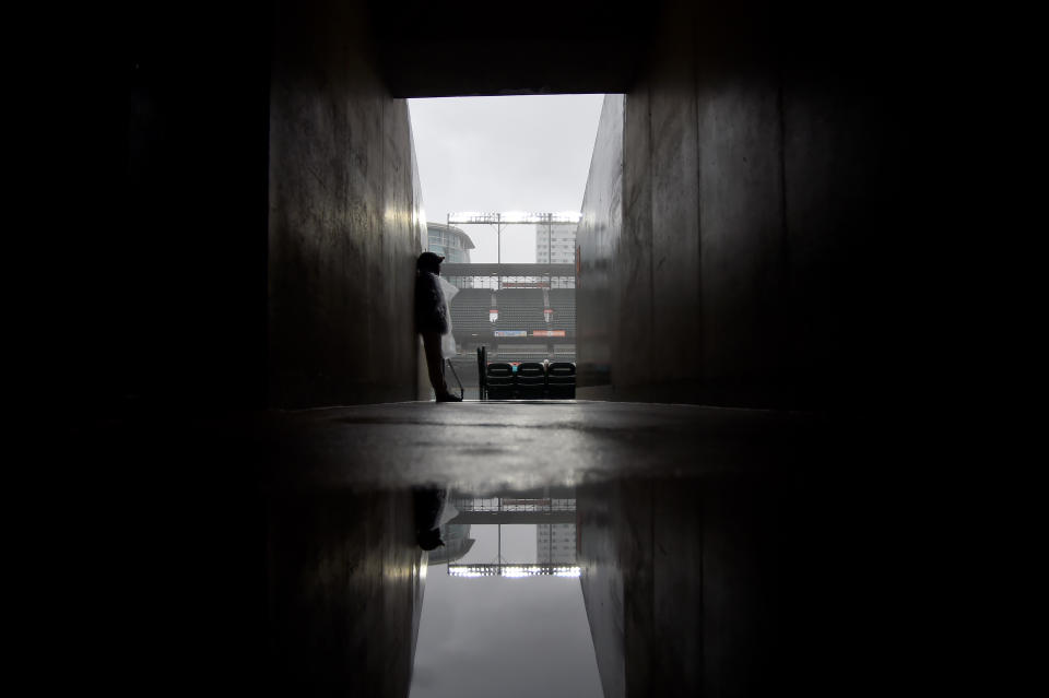 BALTIMORE, MD - MAY 12: An employee of Oriole Park at Camden Yards waits out the rain delay prior to the start of the game between the Baltimore Orioles and the Los Angeles Angels on May 12, 2019 in Baltimore, Maryland. (Photo by Will Newton/Getty Images)