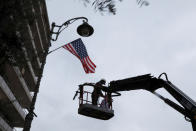 <p>A laborer hangs a U.S. national flag on a lamp post along a street where the U.S. consulate in located in Jerusalem, Dec. 6, 2017. (Photo: Ammar Awad/Reuters) </p>