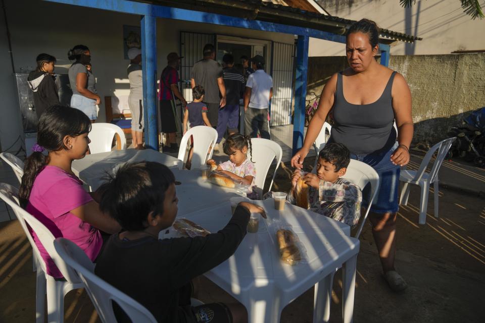 Natalia Contreras, una migrante venezolana, atiende a sus hijos mientras se preparan para desayunar en Rio Branco, Brasil, el 22 de junio de 2024. Migrantes, policías, funcionarios y analistas afirman que la decisión de Joe Biden de suspender temporalmente el asilo ha generado una actitud de espera entre los migrantes que están en Brasil y han paralizado sus planes de llegar a Estados Unidos. (AP Foto/Martín Mejía)