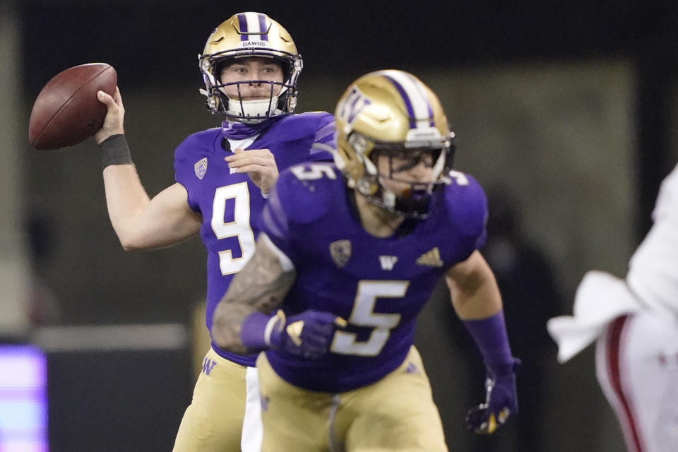 Washington quarterback Dylan Morris, left, drops to pass as running back Sean McGrew (5) takes off from the line of scrimmage during the second half of an NCAA college football game against Utah, Saturday, Nov. 28, 2020, in Seattle. (AP Photo/Ted S. Warren)