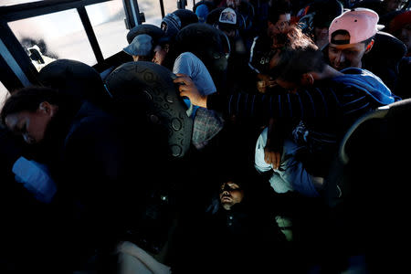 Migrants, part of a caravan of thousands traveling from Central America to the United States, ride on a bus which is on the way to Mexicali, in Navojoa, Mexico November 17, 2018. REUTERS/Kim Kyung-Hoon