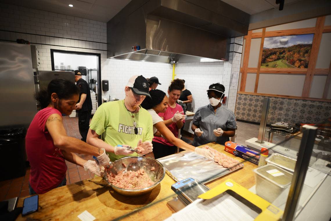 Preparing for the opening of the Old North State Food Hall, employees of Luna Pizza Cafe practice making meatballs.