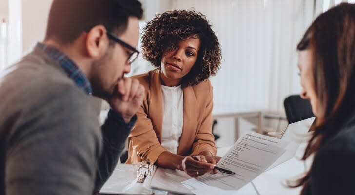 A financial advisor overs over her clients' financial plan with them. Research from the University of Oregon indicates that financial advisor firms acquired by private equity companies are far more likely to engage in misconduct following their acquisition. 