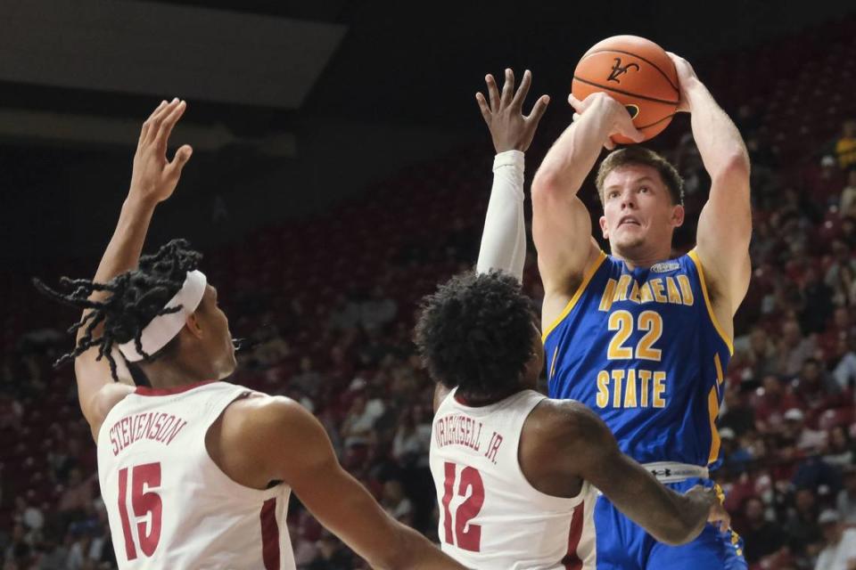 Morehead State guard Riley Minix (22) takes a shot against Alabama guard Latrell Wrightsell Jr. (12) and Alabama forward Jarin Stevenson (15) in a game at Coleman Coliseum in Tuscaloosa, Alabama, on Nov 6, 2023. Mandatory Credit: Gary Cosby Jr.-USA TODAY Sports