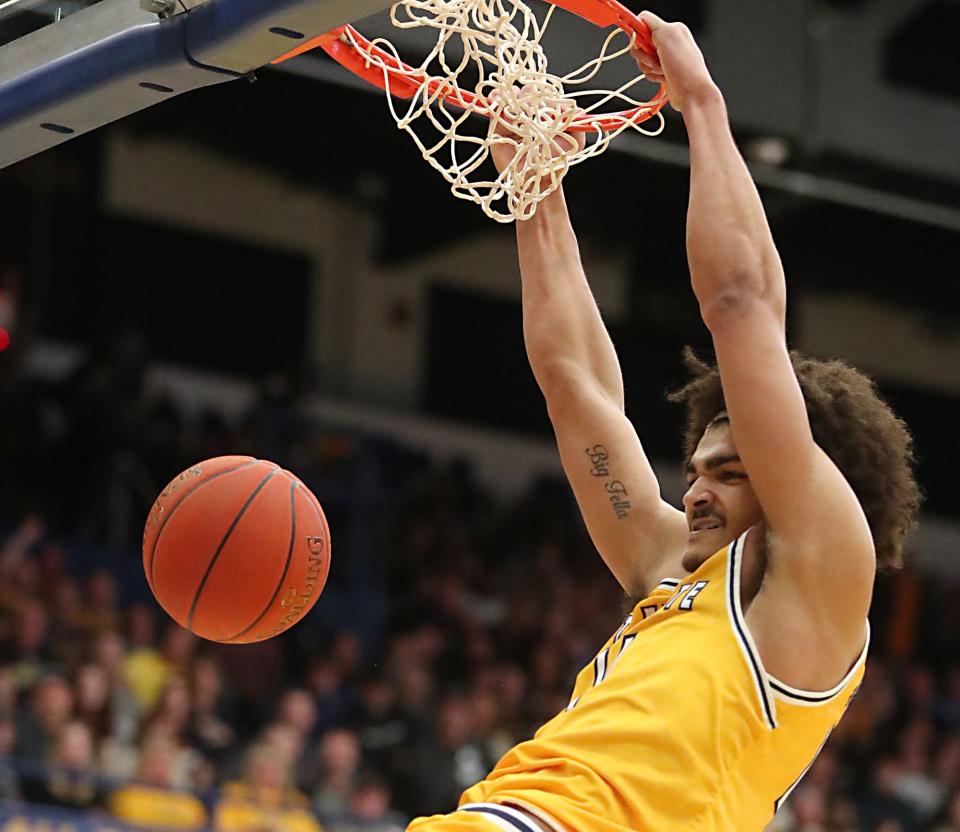 Kent State's Chris Payton hangs on the rim after a dunk against Akron on March 3 in Kent.