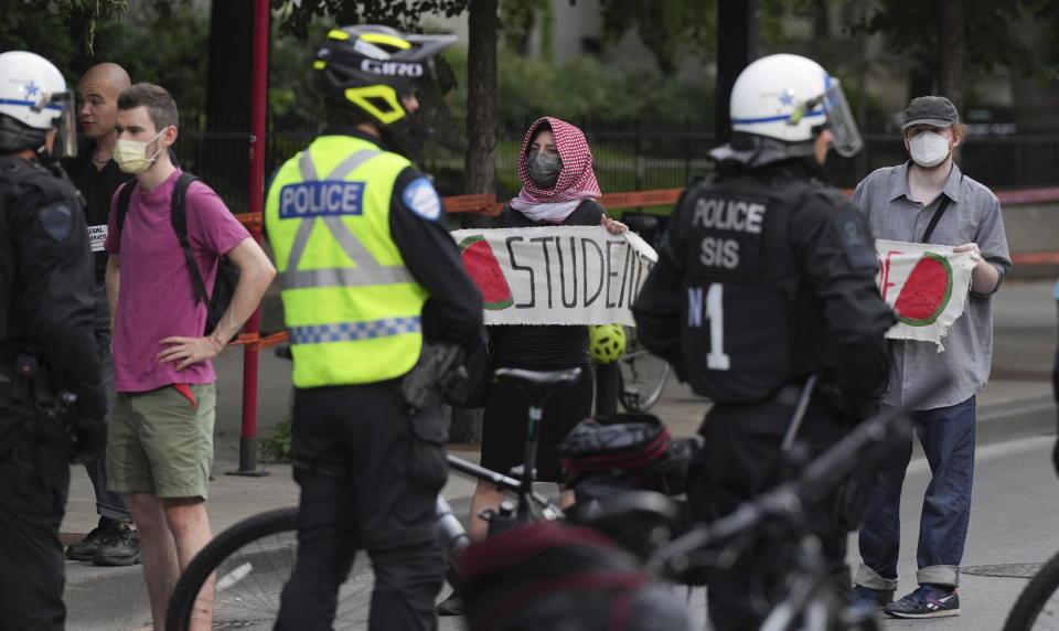 Pro-Palestinian supporters protest in front of police as they cordon off the block around McGill university while school security begins to dismantle their encampment in Montreal, Wednesday, July 10, 2024. (Christinne Muschi/The Canadian Press via AP)