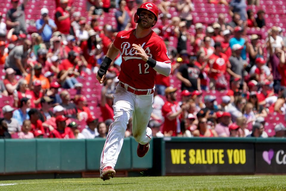 Cincinnati Reds right fielder Tyler Naquin (12) rounds third base to score after a double by Cincinnati Reds first baseman Joey Votto (19) in the sixth inning during a baseball game, Sunday, May 29, 2022, at Great American Ball Park in Cincinnati. The San Francisco Giants won, 6-4.