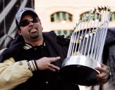 Chicago White Sox manager Ozzie Guillen holds the 2005 World Series trophy during his teams victory rally in Chicago, October 28, 2005. The White Sox won the best-of-seven series against the Houston Astros four games to none. REUTERS/John Gress