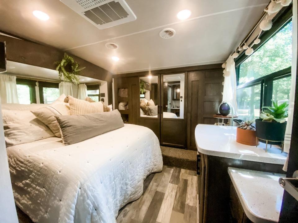 The master bedroom with dark walls and white bedding inside the Proha RV