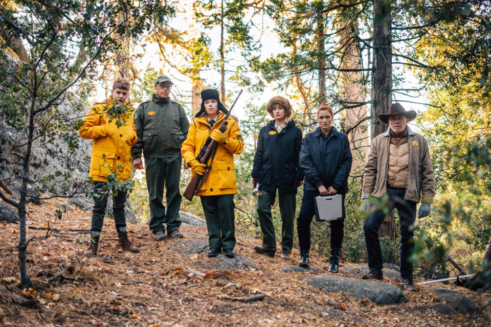 A crew of park rangers look into the forest