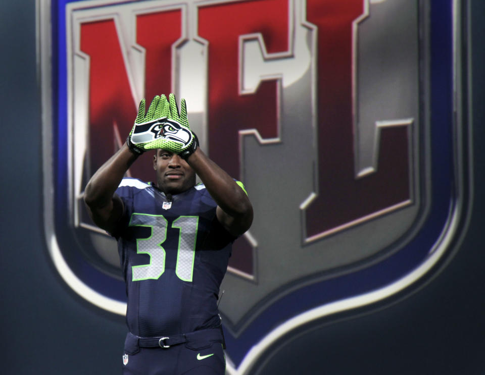 Seattle Seahawks' Kam Chancellor shows off the new design for gloves during a presentation in New York, Tuesday, April 3, 2012.  The NFL and Nike showed off the new look in grand style with a gridiron-styled fashion show at a Brooklyn film studio. (AP Photo/Seth Wenig)