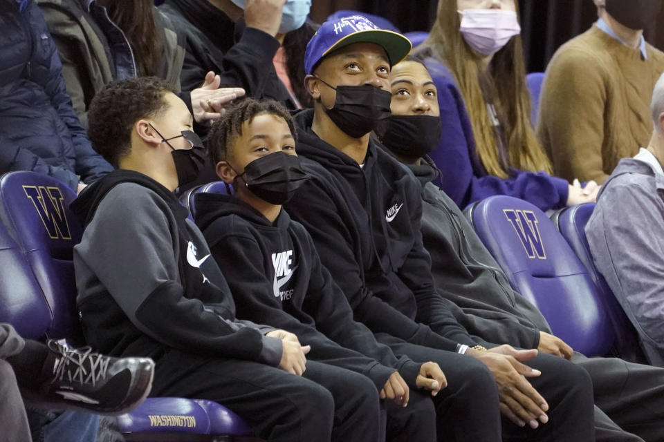 NBA basketball player Isaiah Thomas, third from left, a former guard with the University of Washington, sits courtside during an NCAA college basketball game between Washington and Colorado, Thursday, Jan. 27, 2022, in Seattle. (AP Photo/Ted S. Warren)